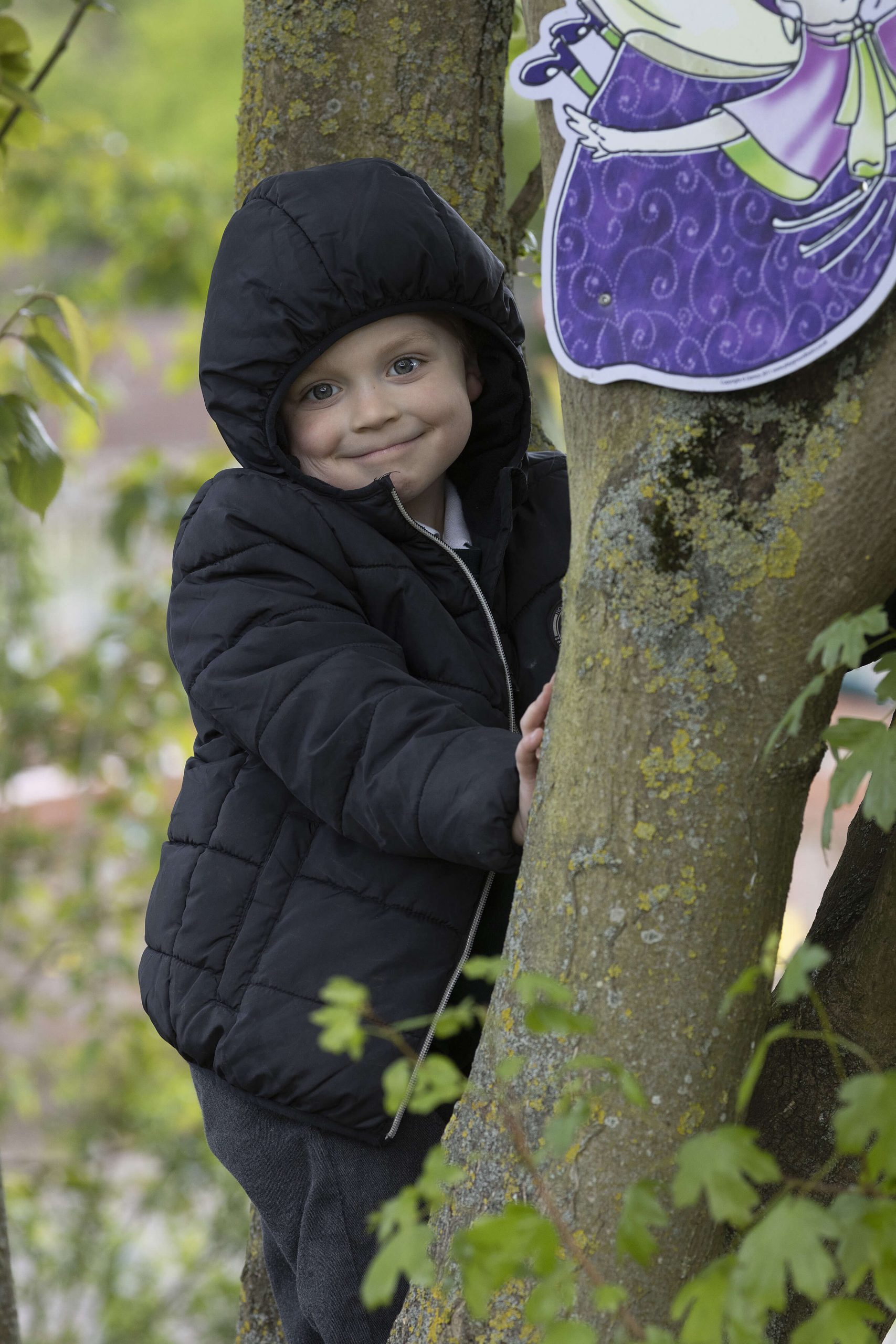 photo of a pupil by a tree smiling