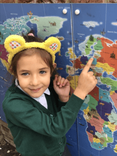 Picture of EYFS pupil pointing at a map in geography lesson